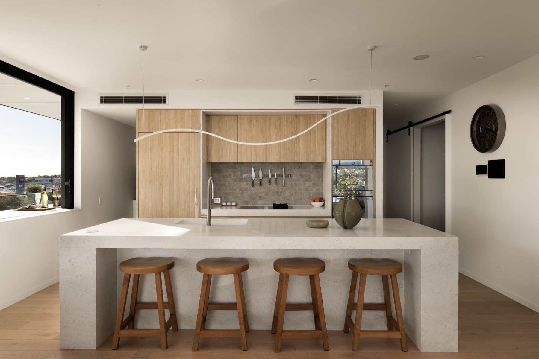 VZUG kitchen with waterfall stone island and timber joinery